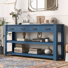 a blue console table with two drawers and a mirror on the wall in front of it