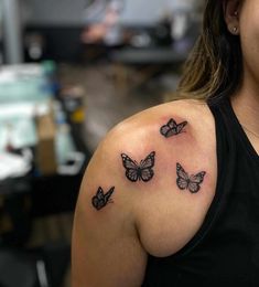 a woman with three butterflies on her shoulder