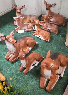 a group of deer figurines sitting on top of a green carpeted floor