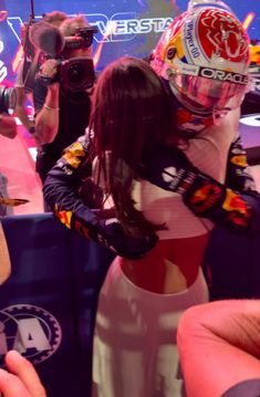 a woman wearing a red bull racing suit