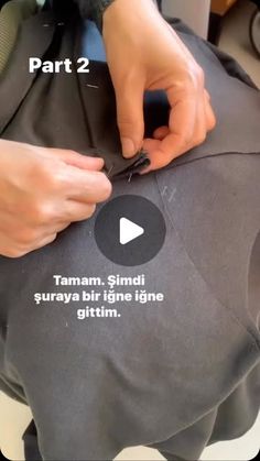 someone is sewing on the back of a bag with words written in white and black