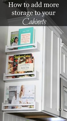 a kitchen with white cabinets and shelves filled with magazines