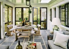 a sun room with couches, tables and lamps on the windowsill is shown