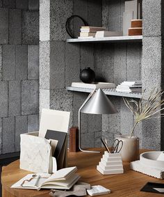 a wooden table topped with books next to a shelf filled with books and other items