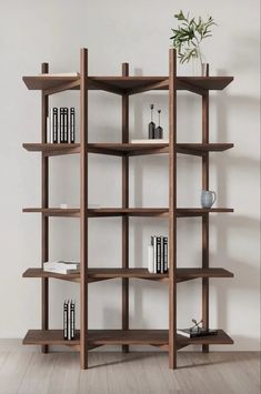 a book shelf with several books on top of it and a plant in the middle