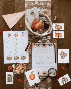 an assortment of autumn themed items laid out on a wooden table with paper and scissors