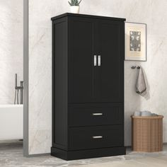 a tall black cabinet with two drawers in a bathroom next to a bathtub and towel dispenser