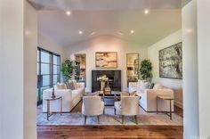 a living room filled with furniture and a fire place in the middle of an open floor plan