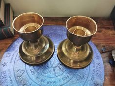 two brass candlesticks sitting on top of a blue mat