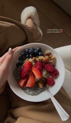 a bowl of oatmeal with strawberries, blueberries and almonds