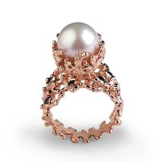 a ring with a pearl in the center and an intricate design on it's side