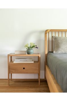 a wooden bed with a nightstand next to it