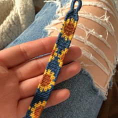 a person is holding a knitted bracelet in their left hand and the other end of her arm