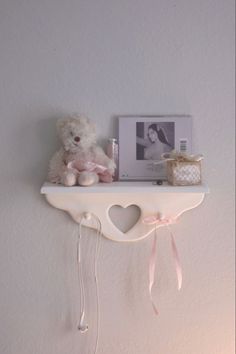 a teddy bear is sitting on top of a shelf with a heart shaped key holder