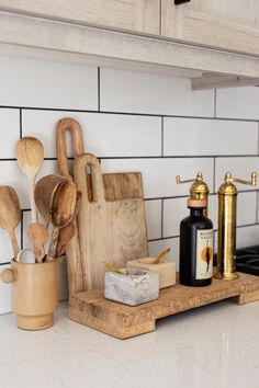 wooden utensils are sitting on a cutting board in the kitchen