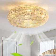 a bamboo light fixture hanging from the ceiling above a bed in a room with white walls