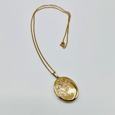 A vintage gold locket pendant, 14kt rolled gold, with engraved flower decoration.  Thos is a lovely gift with pictures of loved ones in it. The brooch is in very good vintage condition, no damages. This pedant and necklace comes within a simple box. The Length of the pendant is Length Width Weight  gram Gold Medallion Locket Necklace Stamped 14k, Antique Gold Locket Necklace Stamped 14k, Vintage Gold Plated Oval Jewelry, Vintage Oval Gold Plated Jewelry, Formal Yellow Gold Filigree Locket Necklace, Anniversary Filigree Yellow Gold Locket Necklace, Ornate Yellow Gold Hallmarked Locket Necklace, Gold 14k Oval Pendant Locket Necklace, Classic 14k Gold Locket Necklace With Oval Pendant