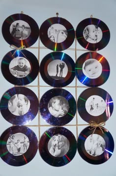 a bunch of cds with pictures on them hanging from a string in front of a white wall