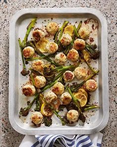 a pan filled with scallops and asparagus on top of a table