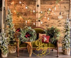 christmas decorations and trees are on display in front of a wood paneled wall with lights