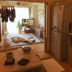 a living room with an open door leading to a kitchen and dining area that has clothes hanging on the rack