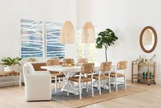 a dining room table with chairs and a potted plant