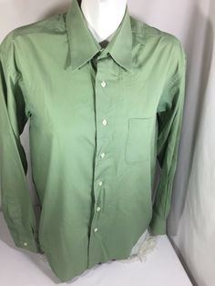 a green shirt is sitting on a mannequin