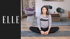 a woman is sitting on the floor doing yoga