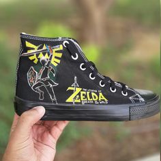 "😍 FREE SHIPPING 😍 Looking for a unique gift for your game-loving partner? Look no further than our Legend of Zelda custom shoes! These black high-top Converse sneakers are hand-painted with iconic imagery from the beloved video game series. Whether they're a fan of Link, Zelda, or the entire kingdom of Hyrule, these shoes are sure to be a hit. Perfect for adults and plus sizes, our custom shoes make a great boyfriend gift or a treat for yourself. Each pair is made to order, so you can be sure Customising Shoes, Plus Size Sneakers, Custom Shoes Men, Great Boyfriend, Loving Partner, Boyfriend Gift Ideas, Baskets Converse, Black High Top Converse, Painted Sneakers