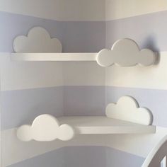 some shelves with clouds on them in a room that is painted blue and white striped walls