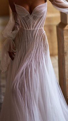 a woman in a white dress is posing for the camera