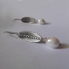 Minimal and elegant white freshwater pearl earrings. These handmade earrings are made from 925 sterling silver, with modern, minimal contemporary design and satin finish are great for everyday wear, but for special occasions also! Great gift for bridesmaids, mother's day or for an anniversary. ► DESCRIPTIONS and MEASUREMENTS: Handmade from 925 sterling silver The black area is oxidized to create contrast in the design. The line sanded to a satin, matte contrast. Pearl size: 18 x 10 mm Oval measu White Sterling Silver Pearl Earrings For Anniversary, Oval Sterling Silver Pearl Earrings, Oval White Pearl Earrings, Minimalist White Pearl Pierced Earrings, Handmade Silver Minimalist Pearl Earrings, Silver Minimalist Pearl Earrings For Anniversary, Minimalist Silver Pearl Earrings For Anniversary, Oval White Gold Pearl Earrings As A Gift, Handmade Silver Oval Pearl Earrings