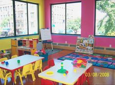 the children's room is brightly colored and has many tables, chairs, and rugs