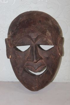 an old wooden mask with eyes and nose