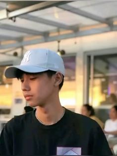 a young man wearing a baseball cap in an airport