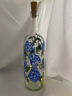 a glass bottle with blue flowers painted on it