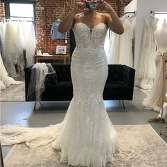 a woman taking a selfie in a wedding dress shop