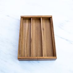 an empty wooden tray sitting on top of a white counter