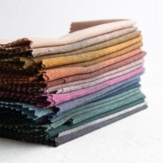 a stack of multicolored cloths sitting next to each other on a white surface