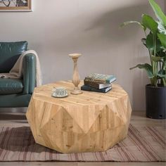 a wooden table sitting on top of a rug next to a chair and potted plant