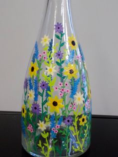 a glass vase with flowers painted on it