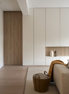 a living room with white walls and wooden slats on the wall next to a couch