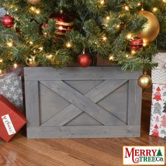 a christmas tree with presents under it and a merry tree in the back ground next to it