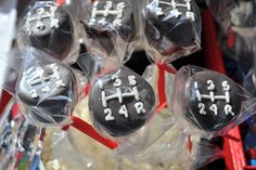 black and white decorated cake pops in plastic wrappers on display at a candy store