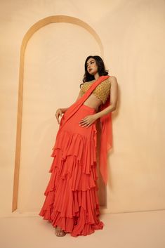 Featuring a peach pre-stitched, drape ruffle saree, with intricate cutdana and beads work on blouse of the saree. The saree is made up of Georgette and Net. Floor-length Ruffled Saree For Reception, Pre-draped Ruffled Saree For Diwali, Anarkali Saree With Ruffles In Traditional Drape, Anarkali Pre-draped Saree With Ruffles, Designer Ruffled Floor-length Saree, Pre-draped Saree With Ruffles For Festivals, Designer Floor-length Ruffled Saree, Traditional Drape Saree With Ruffles For Festivals, Bollywood Style Floor-length Saree With Ruffles