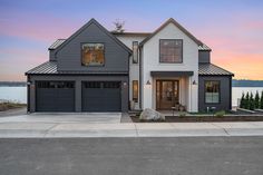 a large house with two garages on the front and side of it at sunset