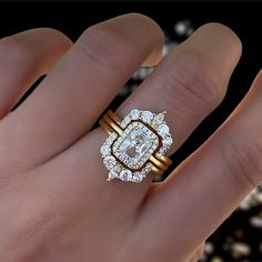 a woman's hand with a gold ring and diamond engagement ring on her finger