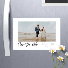 save the date photo magnets with daisies in front of a refrigerator freezer