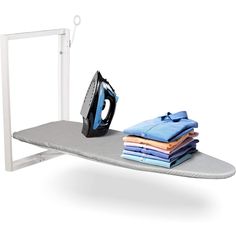 an ironing board with clothes on it next to a black and white electric iron