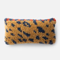 an animal print pillow with blue and orange details on the front, sitting on a white surface